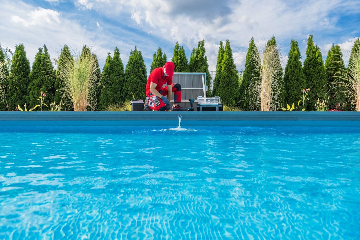 A professional pool technician performing dedicated seasonal pool maintenance