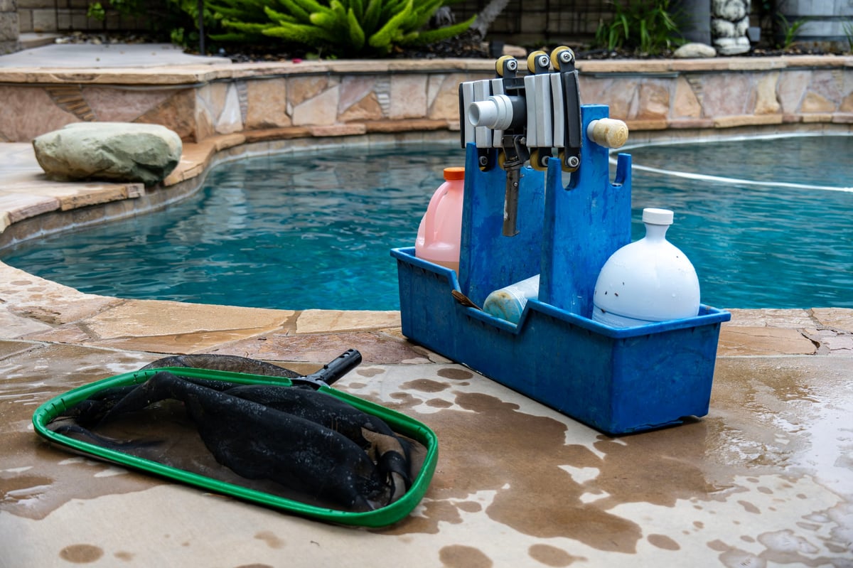 The tools and cleaning chemicals a pool man will use to clean clients' pools